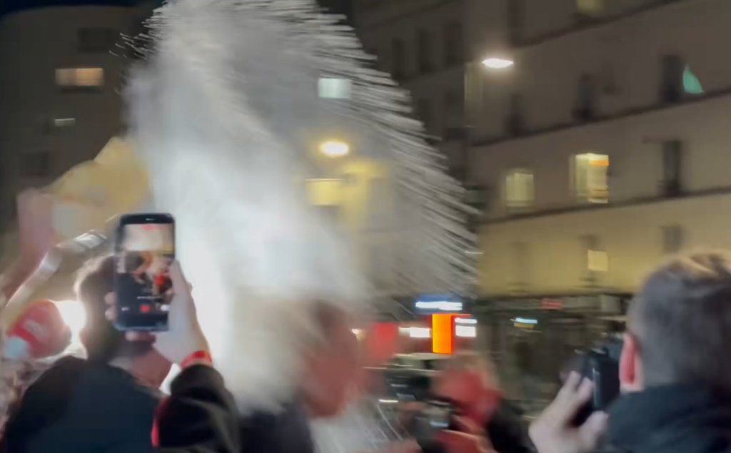 Raphaël Glucksmann aspergé de farine à la sortie de la Cantine de Belleville à Paris, le soir de sa victoire à la primaire à gauche, entouré de personnes filmant avec leur téléphone