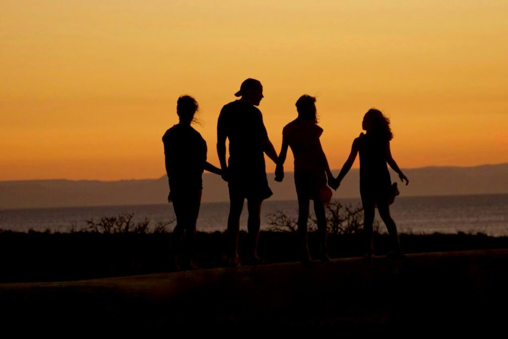 Famille main dans la main au coucher du soleil