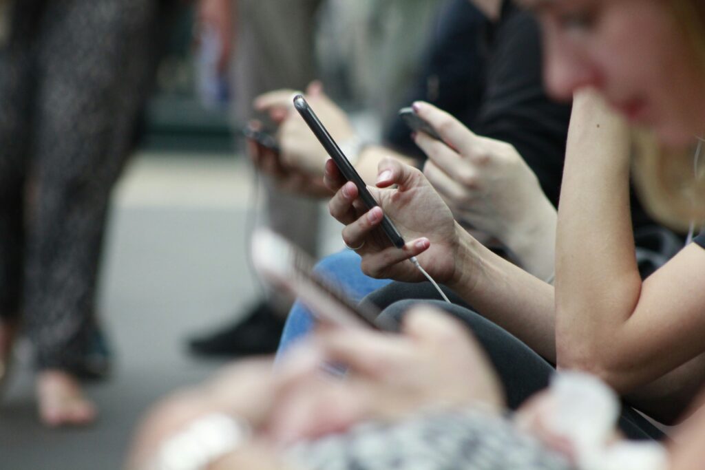 Des personnes assises consultent leur téléphone portable